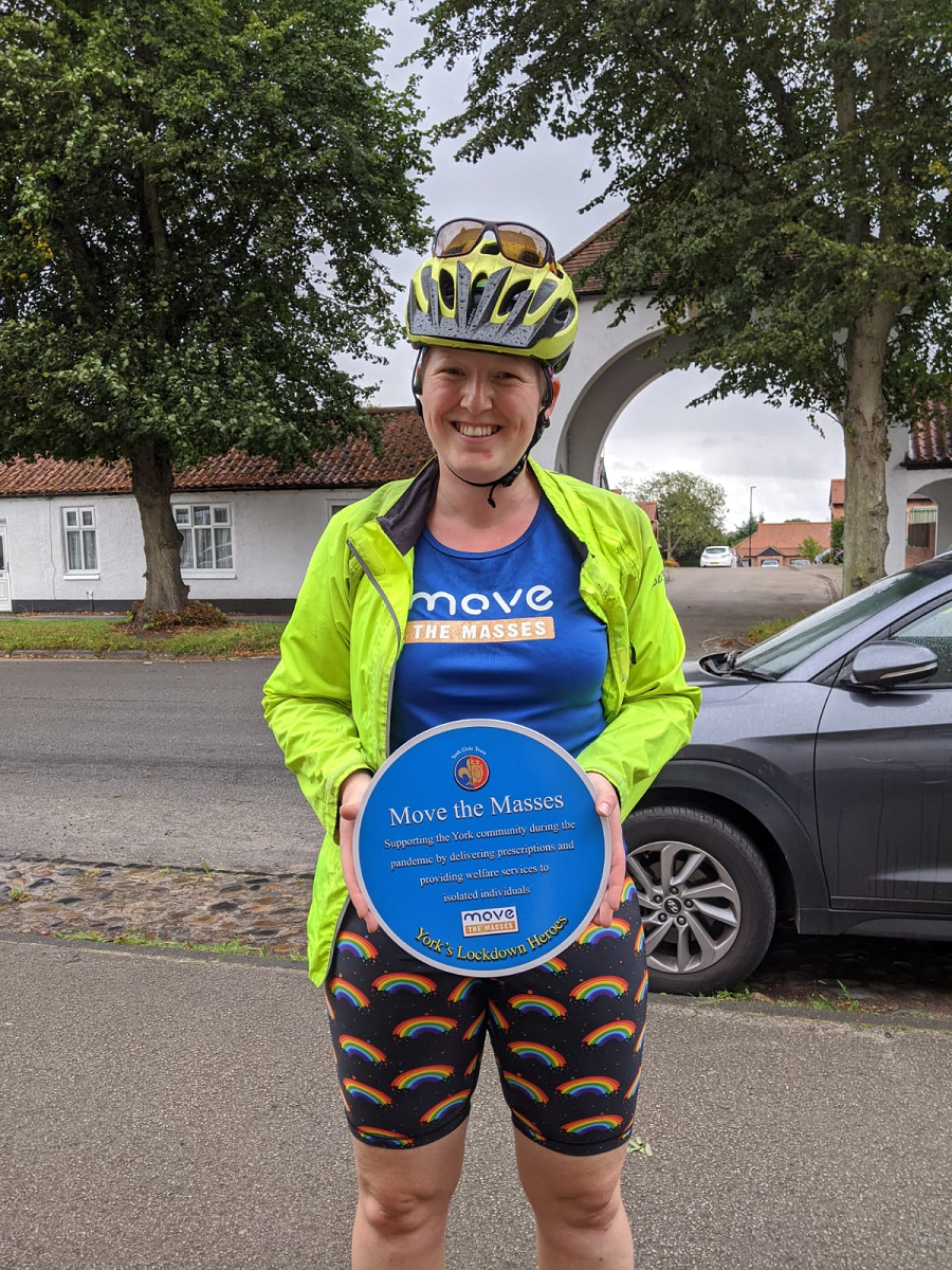 Debs holding plaque in cycling gear